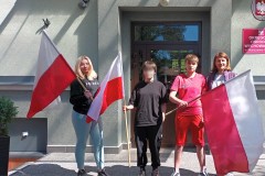 Wychowanki z flagami Polski przy wejściu do Ośrodka.