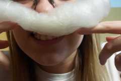 Wychowanka przykłada watę cukrową w kształcie wąsów do twarzy.