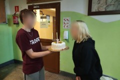 Wychowanka wręcza tort jubilatce.